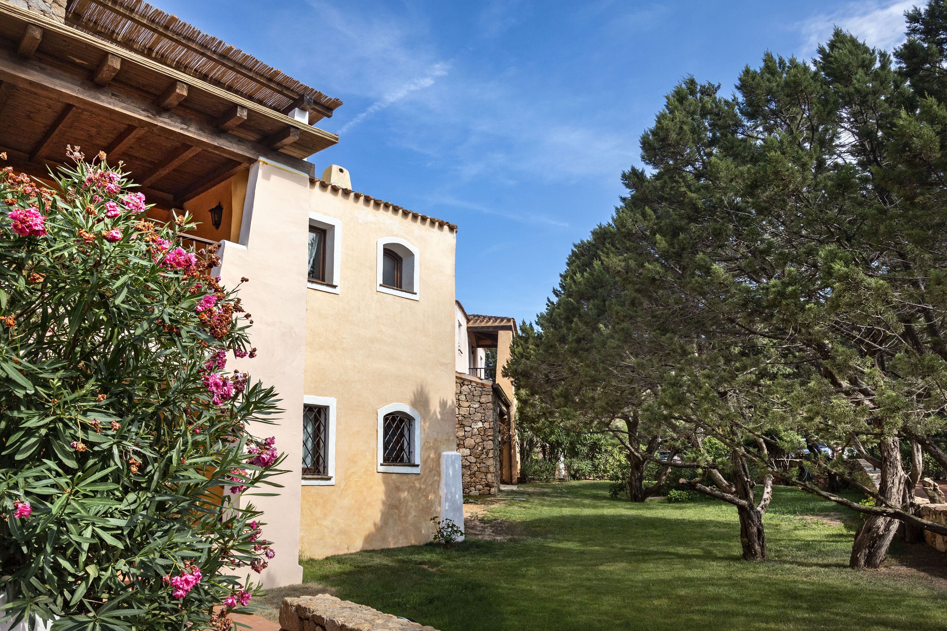 A traditional Mediterranean-style building with a stone facade, arched windows, and a wooden roof.