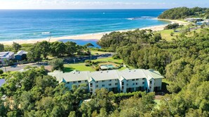 Un resort con piscina, campo da tennis e vista sulla spiaggia.