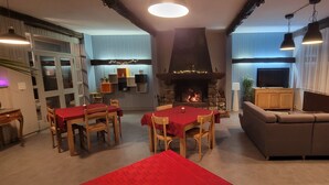 Ein gemütliches Wohnzimmer mit Kamin, Fernseher und einer Couch.