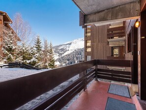 Ein Holzbalkon mit Blick auf schneebedeckte Bäume und Berge.