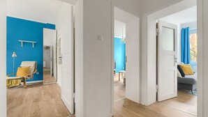 A modern interior with a wooden floor, a blue accent wall, and a seating area with a chair and a table.