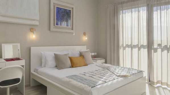 A modern hotel room with a large bed, a bedside table, a chair, and a window with sheer curtains. - Royal Green (Moka)
