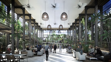 A spacious indoor area with high ceilings, modern seating arrangements, and large windows allowing natural light.