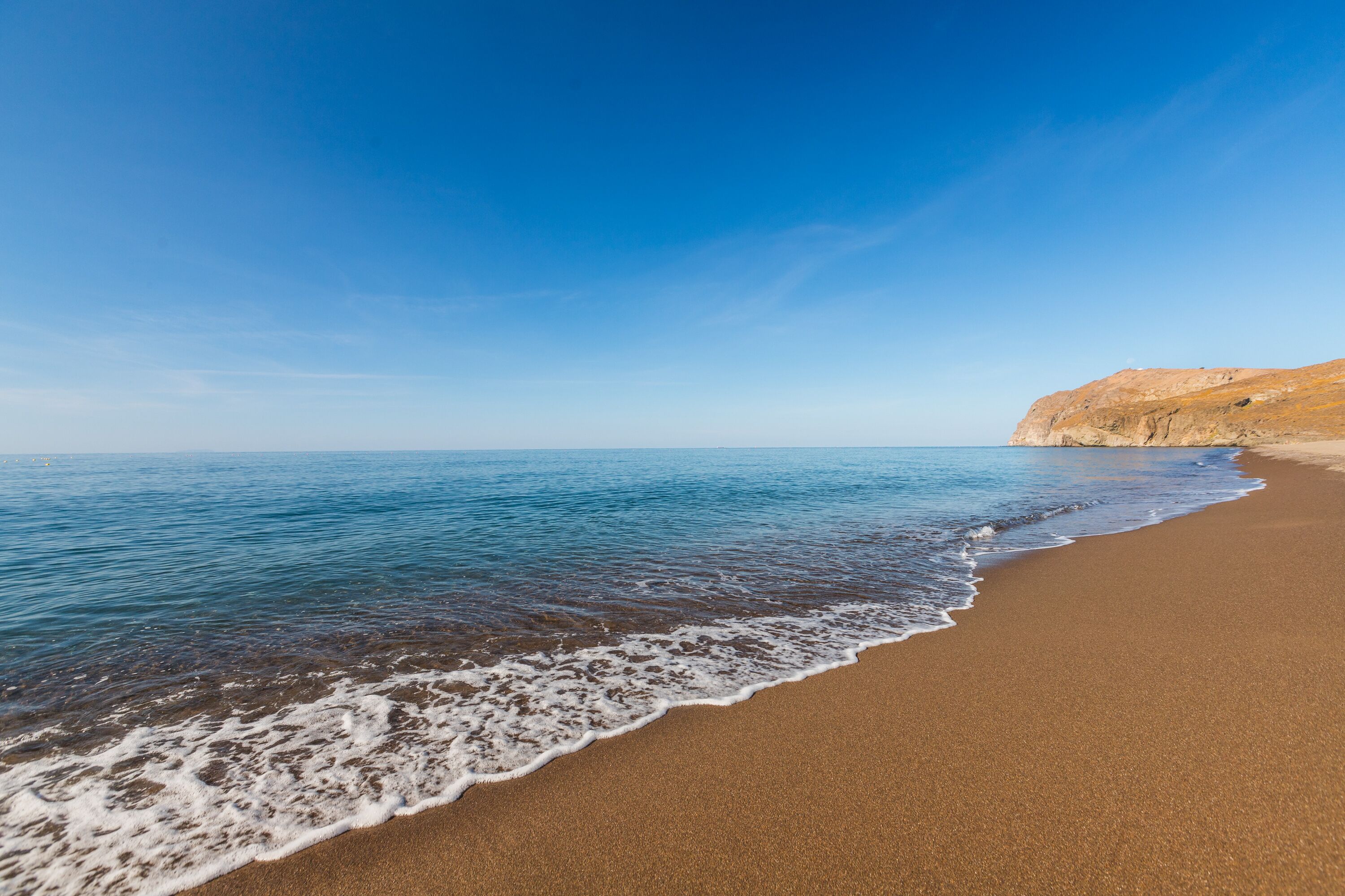 A beach with a clear sky and calm sea.
