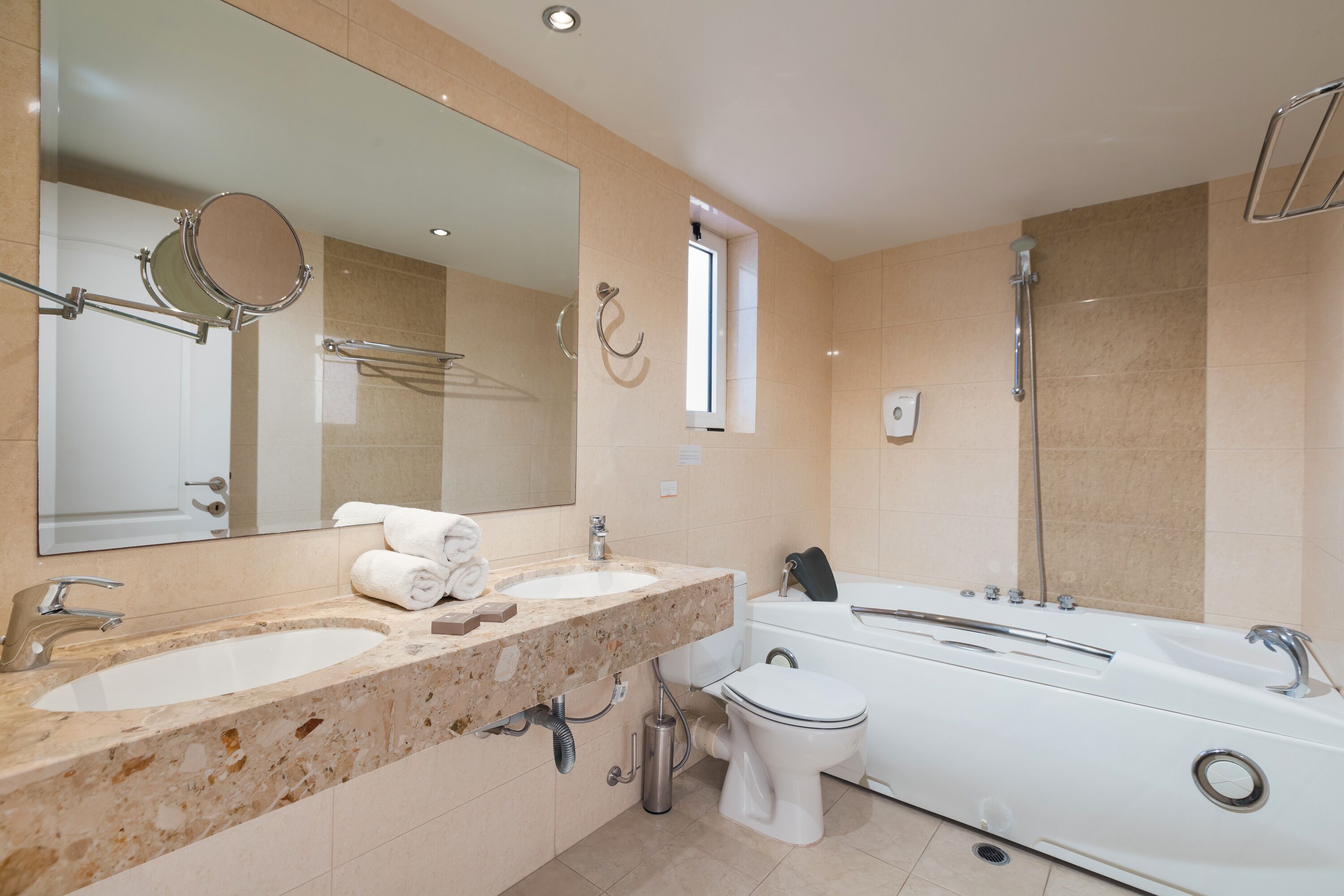 Un baño moderno con dos lavamanos, un inodoro y una bañera.