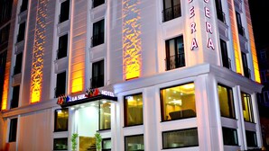 A hotel with a modern facade, multiple floors, and illuminated signage. - Hotel La SERA (Istanbul)