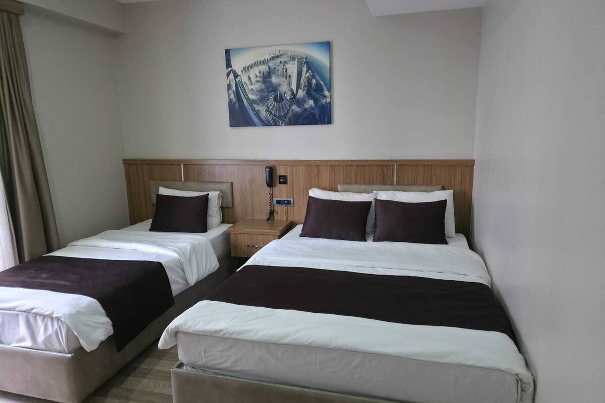 Ein Hotelzimmer mit zwei Betten, einem Holzkopfstück, einem Telefon und einem Bild an der Wand.