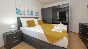 A modern bedroom with a bed, bedside tables, a wardrobe, and artwork on the wall. - Apartments Adela I (Novalja)