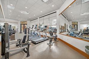 A gym with treadmills, weight machines, and mirrors.