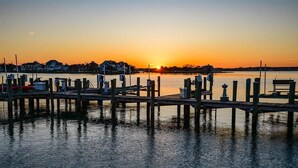 Eine Uferpromenade mit einem Sonnenuntergang im Hintergrund.