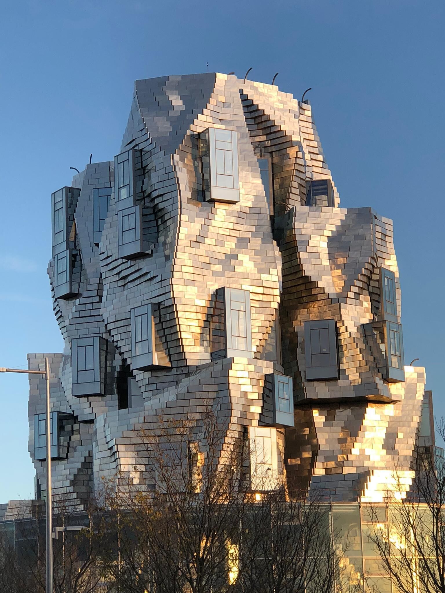 A modern building with a unique, angular design featuring multiple protruding sections and windows.