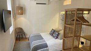 A bedroom with a bed, a chair, a TV, and a wooden wardrobe. - Townhouse Terrace Beauduc, Arles (Arles)