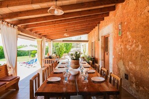 Enjoy meals in this cozy dining area with a long table, wooden chairs, and a large bowl at its center.