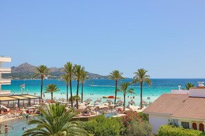 A resort with a pool area, beach, and mountain views.