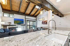 A modern kitchen with granite countertops, a built-in oven, and a large island with a sink.