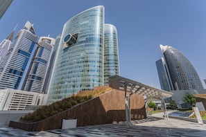 A modern urban area with high-rise buildings, a pedestrian walkway, and a solar panel structure.