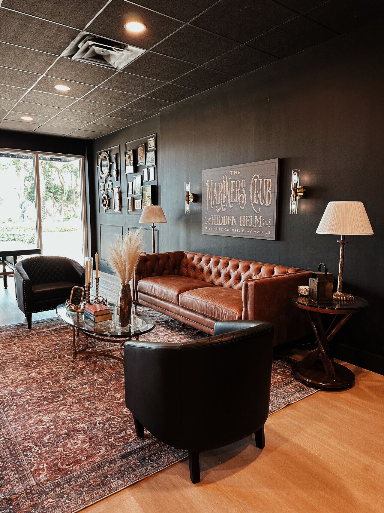 A modern lounge with a leather sofa, a round coffee table, and a rug.