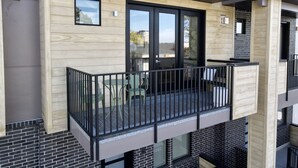 A modern apartment with a balcony, wooden facade, and black railings. - Luxury Downtown Spacious 3 bedroom New Modern Townhome (Provo)