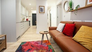 Un salon moderne avec un canapé en cuir marron, un tapis coloré et une petite table ronde.