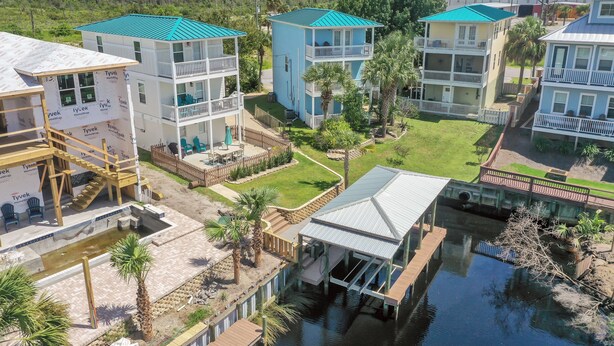 A waterfront property with multiple buildings, a dock, and a small pool.