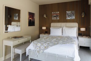 A hotel room with a bed, a bedside table, a desk, a chair, a mirror, and a wall with vertical wooden slats. - Amazing Villa Boron! View of the Sea, Pool, and Hot Tub (Nice)