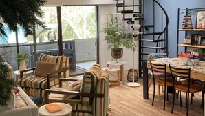 Un salon moderne comprenant un canapé, des fauteuils, une table à manger et un escalier.