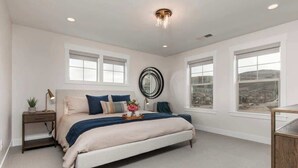 A bedroom with a bed, bedside tables, a mirror, and large windows. - Alpine Adventure Haus! 4BR Townhome 15m to Main (Heber City)