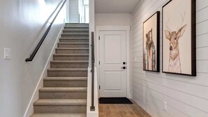 A staircase with carpeted steps, a white door, and two framed deer paintings on the wall. - Alpine Adventure Haus! 4BR Townhome 15m to Main (Heber City)