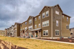 A multi-story residential building with a flat roof, multiple windows, and a covered front porch.