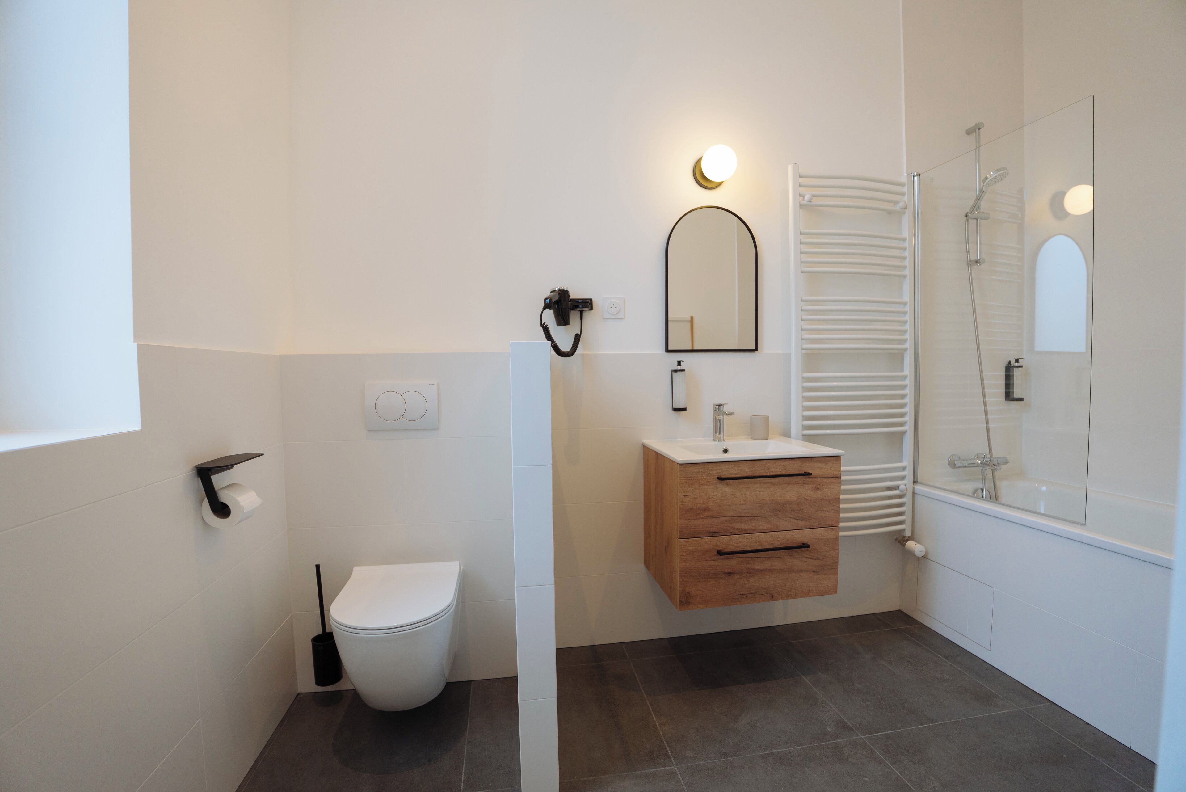 Une salle de bain moderne équipée de toilettes, d’un lavabo et d’une douche.
