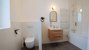 Une salle de bain moderne équipée de toilettes, d’un lavabo et d’une douche.