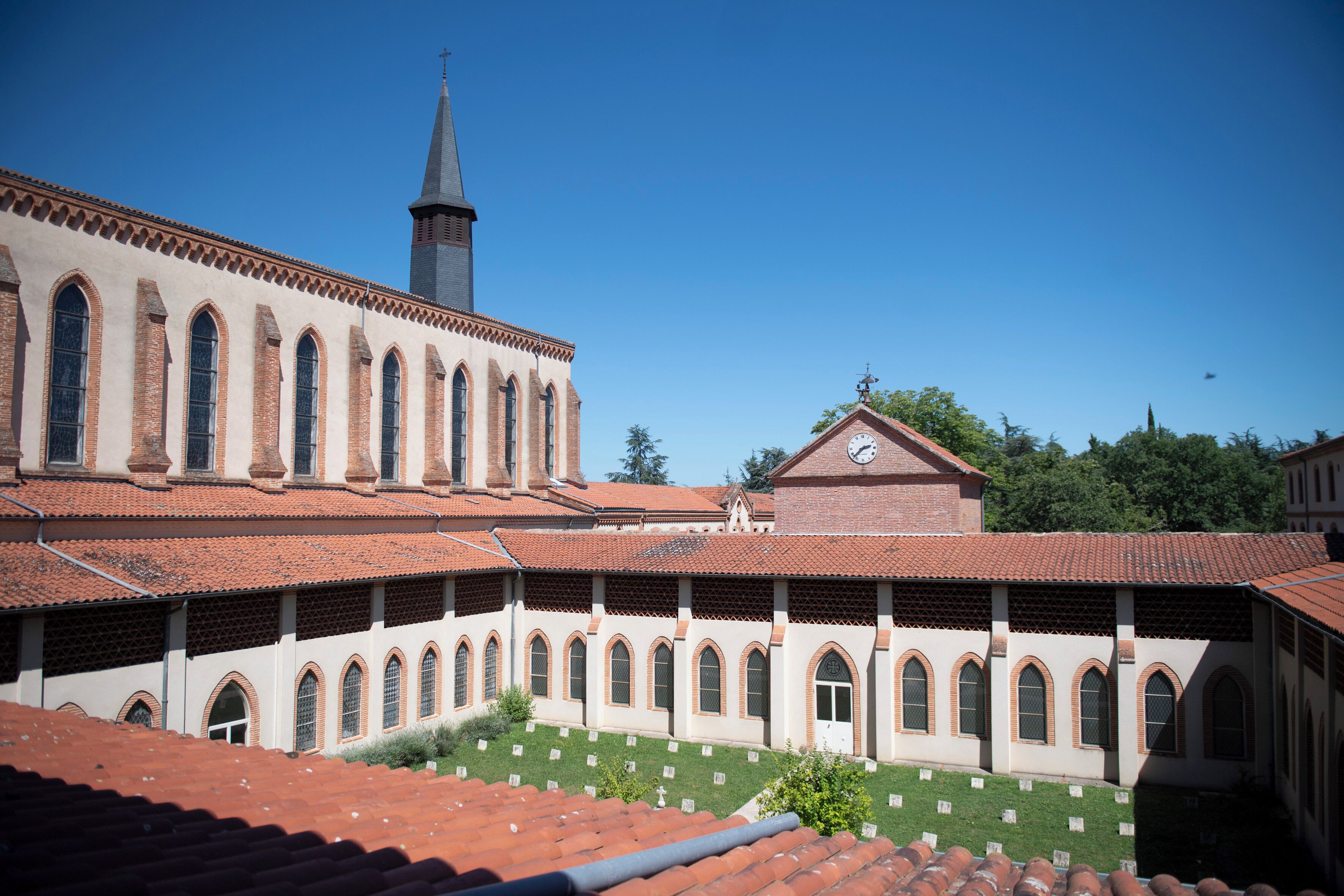 A courtyard with a church and a clock tower.