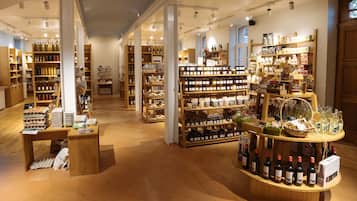 A well-lit store with wooden shelves stocked with various products, including bottles and jars.