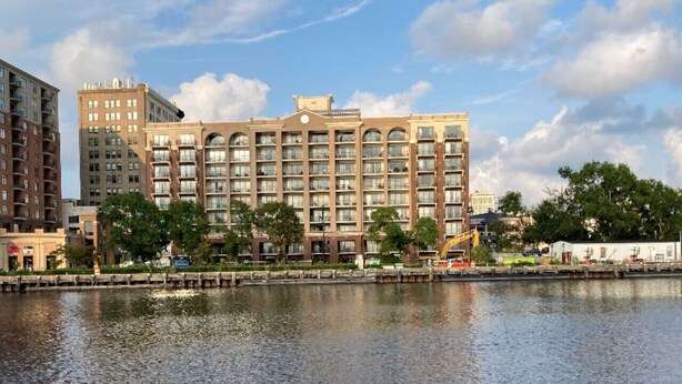 A multi-story hotel with a central courtyard and a waterfront view.