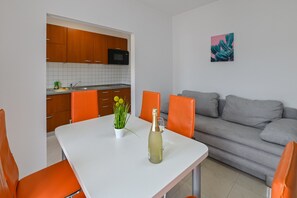 Departamento Confort, 1 habitación, Terraza, vista al mar | Área de sala de estar | Televisión de pantalla plana de 30 cm con canales por cable 