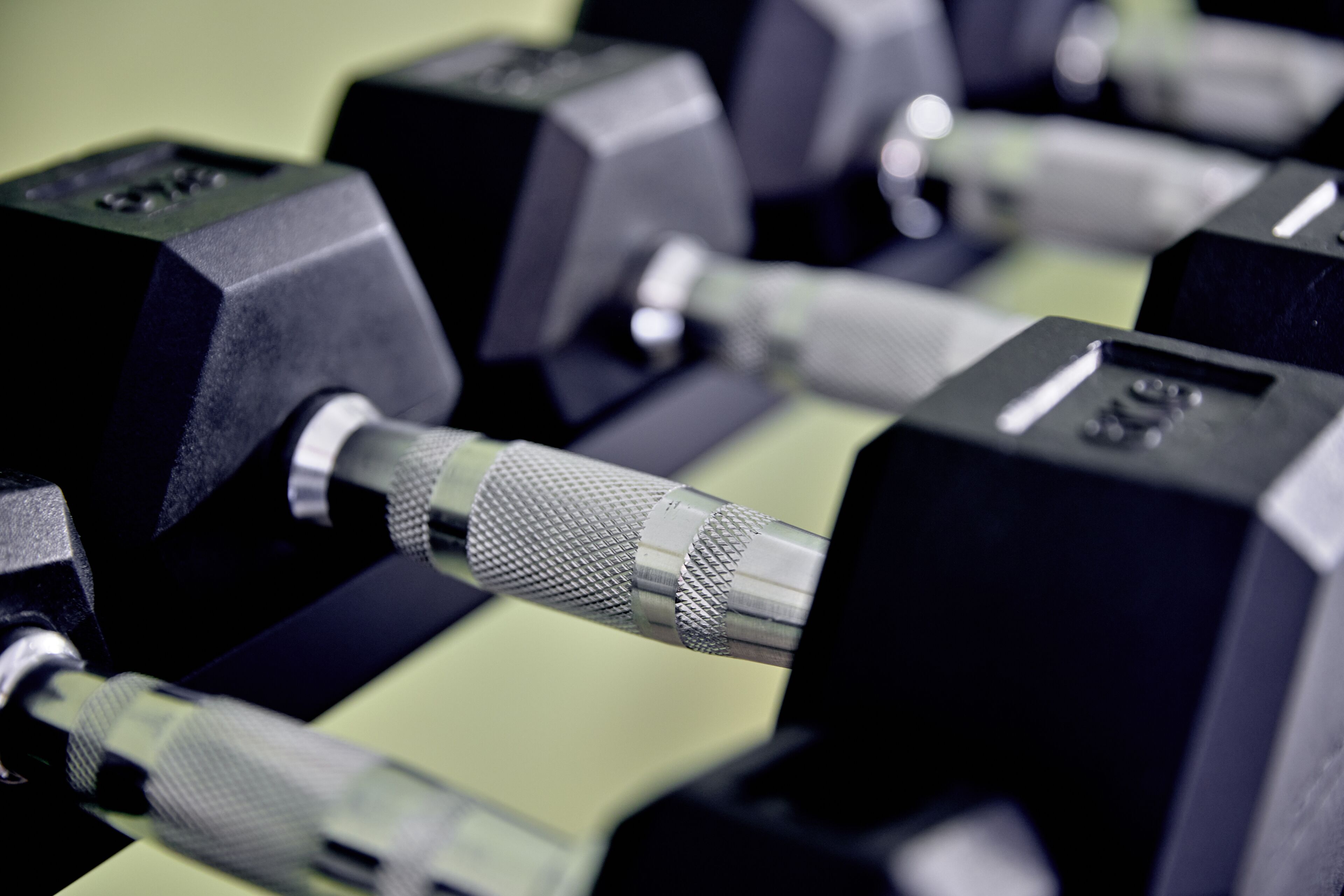 A close-up of a set of dumbbells with adjustable weights, indicating a gym or fitness equipment area.