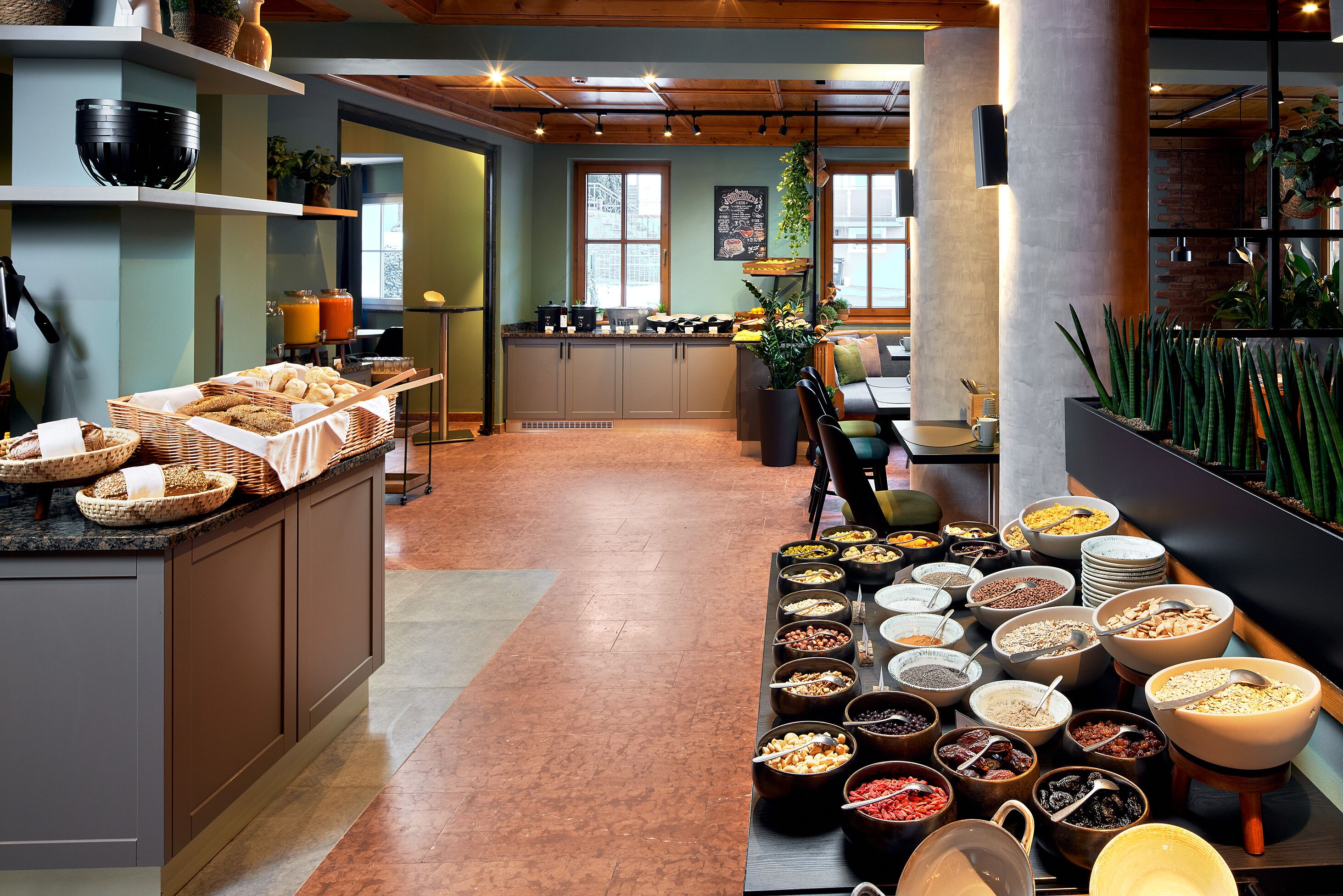 En buffet med forskellige retter og et køkken i baggrunden.