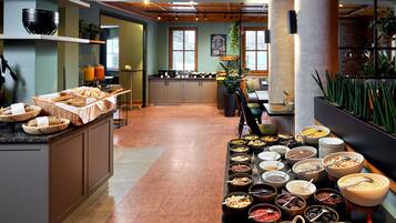 En buffet med forskellige retter og et køkken i baggrunden.