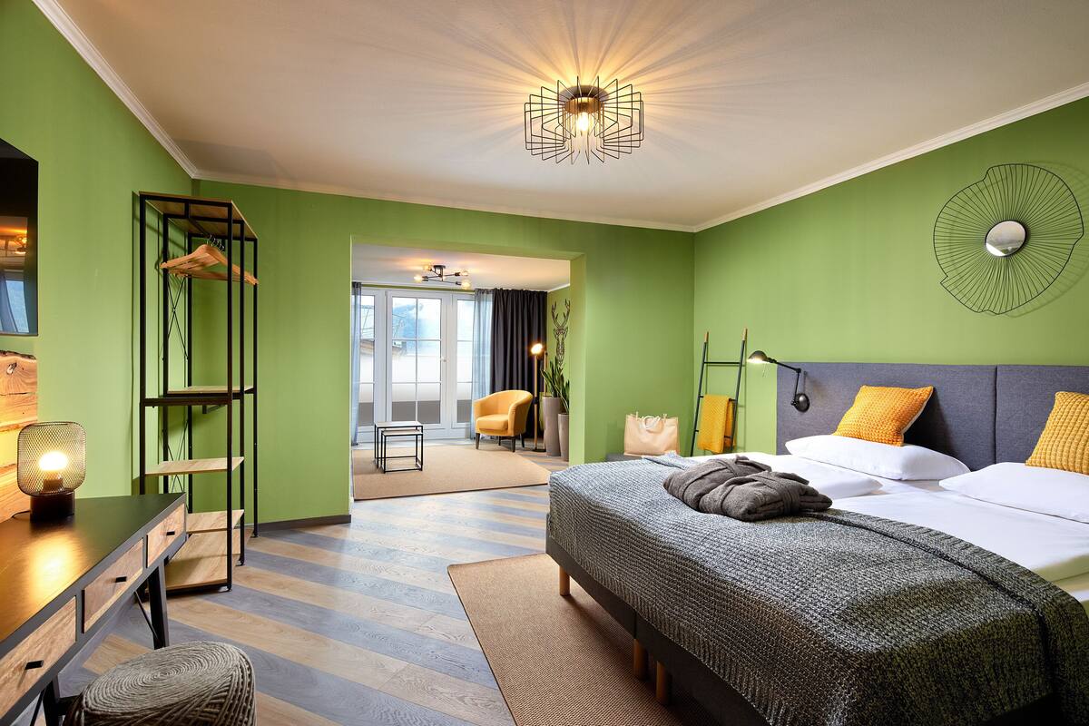 A modern bedroom with a bed, a desk, and a chair.