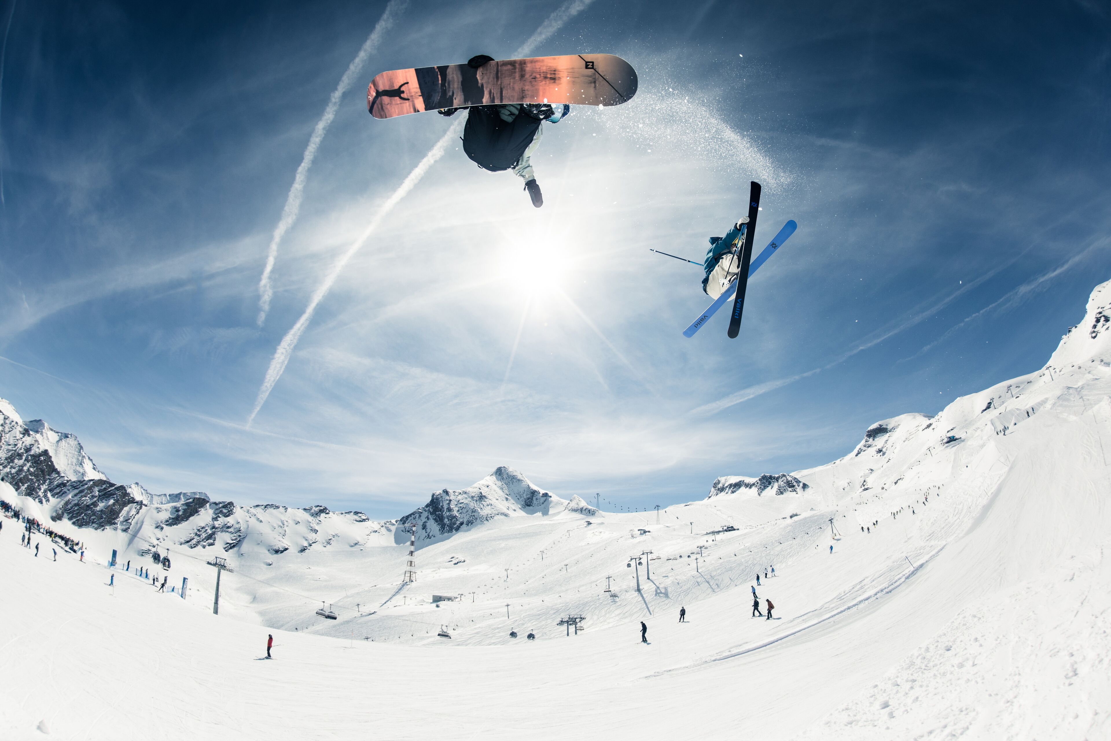 A snowboarder performing a jump in a snowy mountain setting.