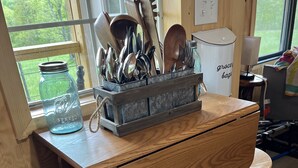 A kitchen with a wooden countertop, a storage box with utensils, a trash bin, and a window with a view of greenery. - Fox Pen Cabins
Cabin #2
Not friendly for street bikes…
Pet-Friendly (Eminence)
