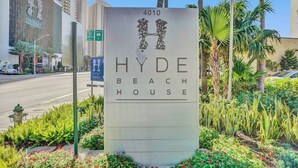 Een bordje voor Hyde Beach House, met een modern design, een logo en adres.