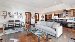A spacious living area with a sofa, coffee table, and dining table.