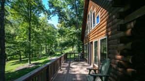 A wooden cabin with a deck, surrounded by trees. - Eagle Bend Lodge-center of Pine Creek Rail Trail (Brown Township)