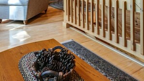 A wooden interior with a staircase, a sofa, and a dining area. - Eagle Bend Lodge-center of Pine Creek Rail Trail (Brown Township)