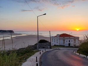 A coastal road with a building featuring a red roof and a stone wall. - Amazing Views of Lagoa and Sea!!! (Foz do Arelho)