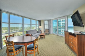 Enjoy a panoramic city view from the comfort of this stylish room, featuring a large dining table, sofa, and cabinet with drawers.
