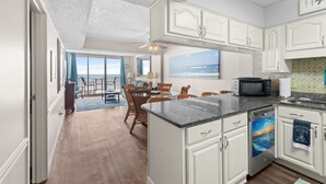 A kitchen with white cabinets, a granite countertop, and a dishwasher. - Crescent Sands of Windy Hill  F4-3BR/3BA Oceanfront condo in Crescent Beach (North Myrtle Beach)