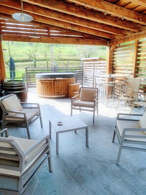 A wooden cabin with a hot tub, outdoor seating, and a view of the surrounding greenery. - A vacation in the midst of nature just a stone's throw from Alba? (Alba)