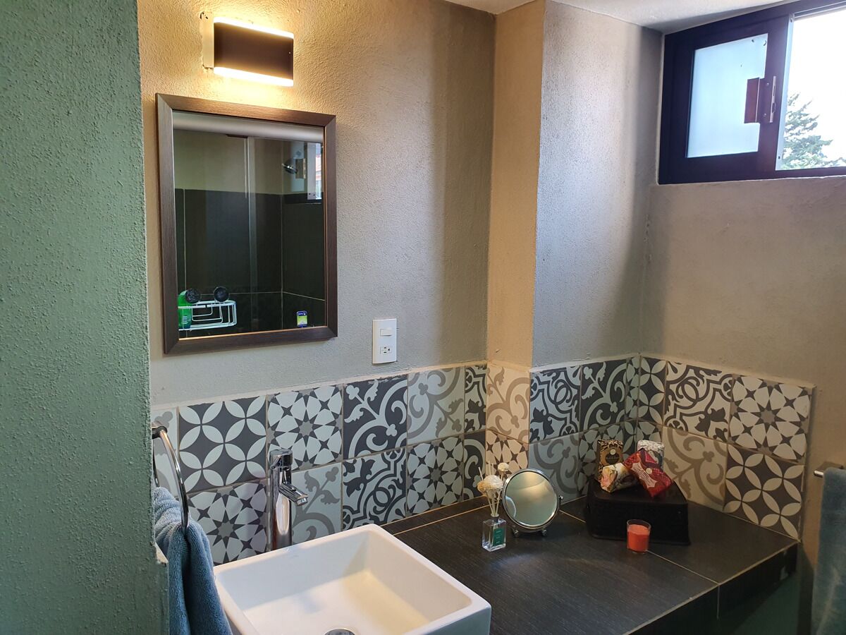 A bathroom with a sink, mirror, and decorative items on the counter.
